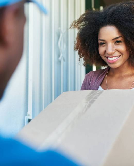 Shot of a postal worker delivering a package to a young female customer. Shot of a postal worker delivering a package to a young female customer.